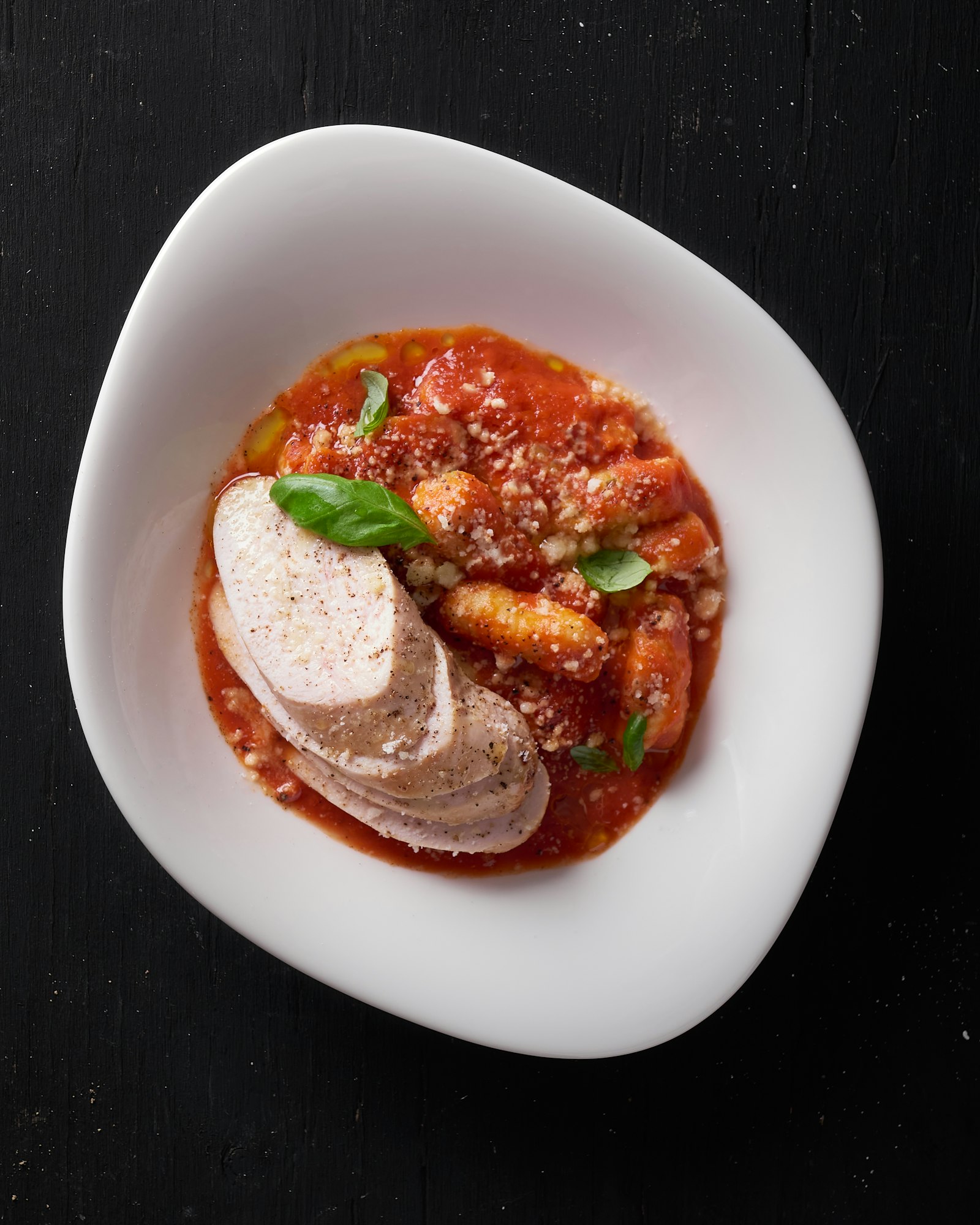 A finished sous-vide dish, sliced and plated with sauce and garnish
